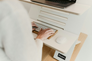 A person typing at a well-set-up ergonomic desk with good posture